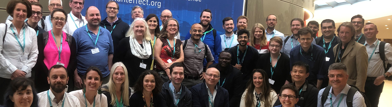 A group photo of the MAVE workshop attendees, held a day prior to the Mutational Scanning Symposium 2023. The attendees are posing for a group photo, in front of a blue banner for the Atlas of Variant Effects Alliance. Image credit: Wellcome Sanger Institute