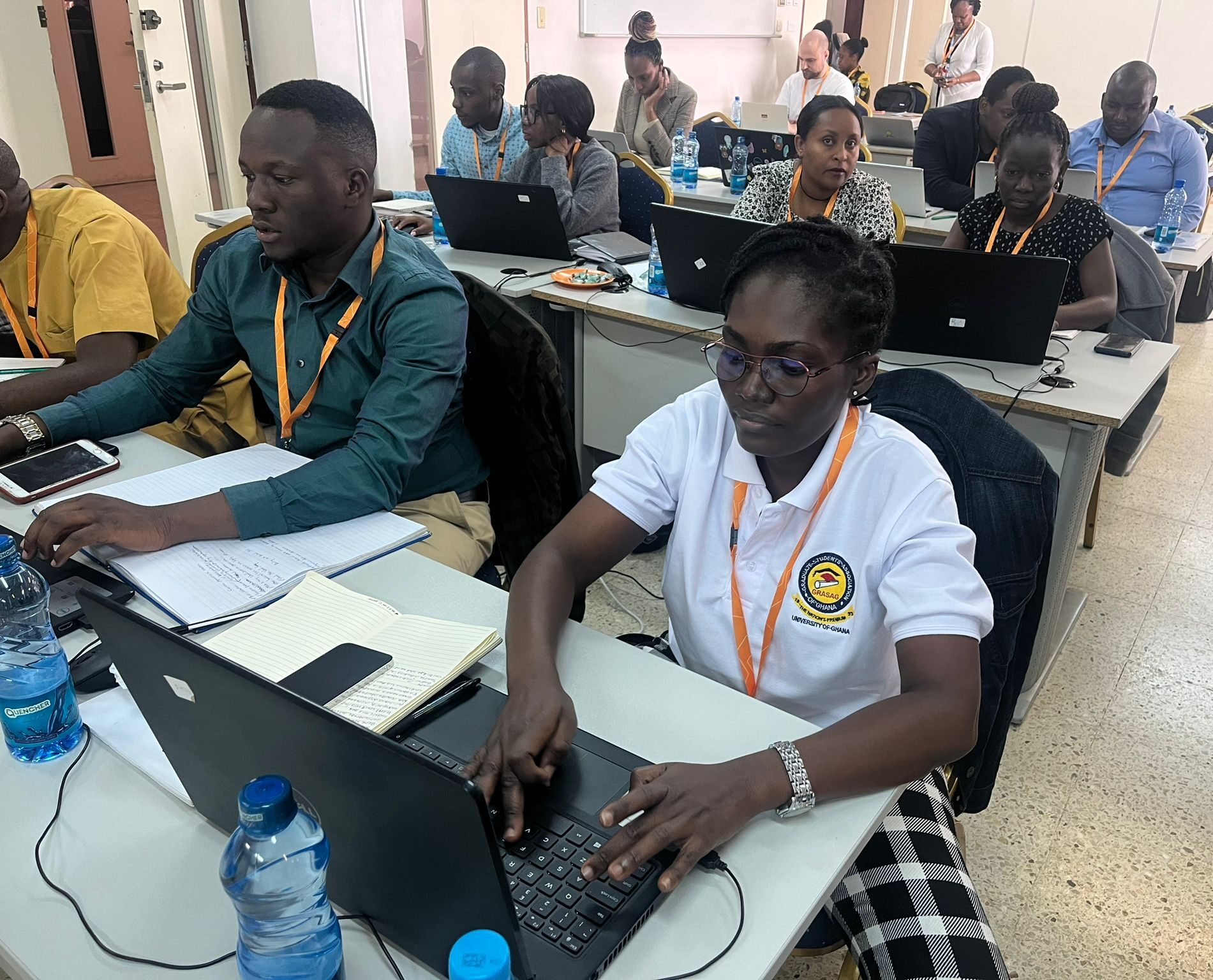 Course participants seated at laptops in a classroom. 