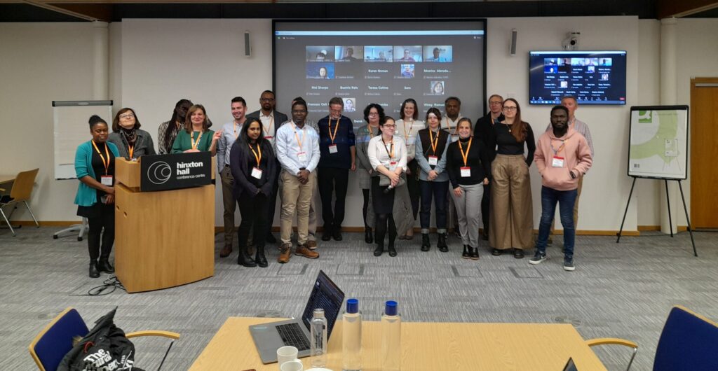 A group of T3connect trainees standing at the front of a classroom, posing for a group photo. They are standing in front of a podium. 